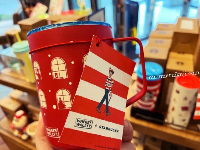 スターバックスとウォーリーのコラボデザインが施された赤いステンレスカップ(473ml)を手に持った様子